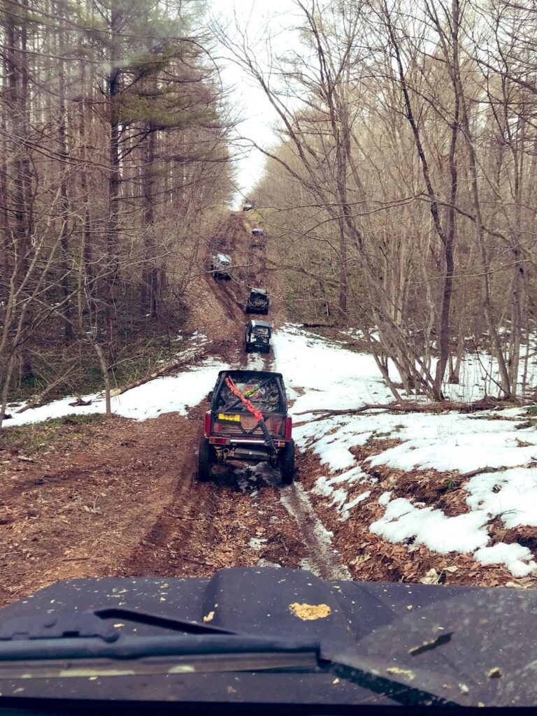 雪の残る林道を進むジムニーの列